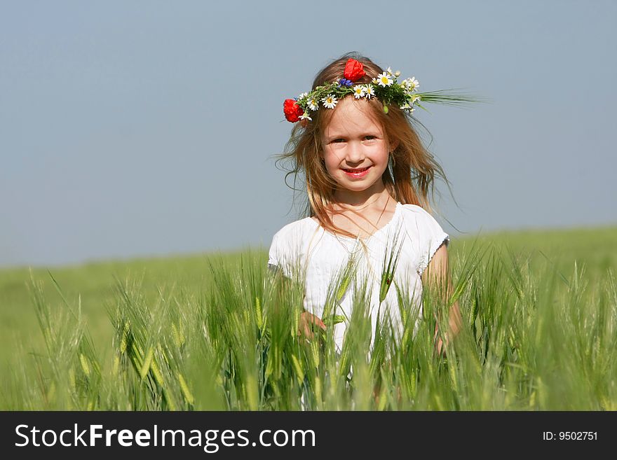 Cute girl on green field portrait