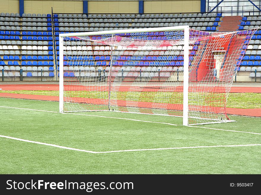 The image of a stadium and a goal under the foreground