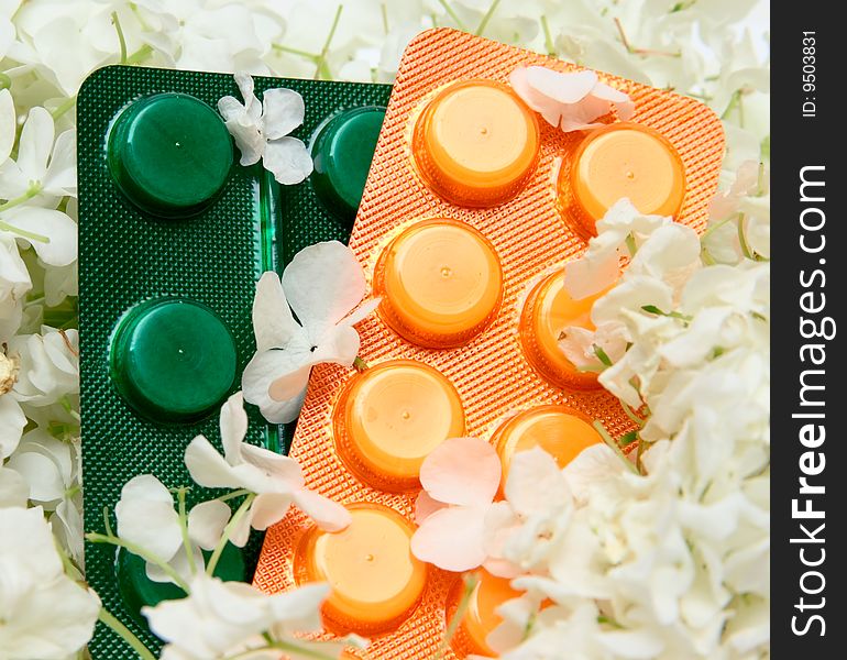 Homeopathic pills and flowers background