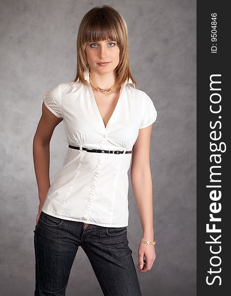 Cowgirl in a hat on a grey background possing in a studio. Cowgirl in a hat on a grey background possing in a studio