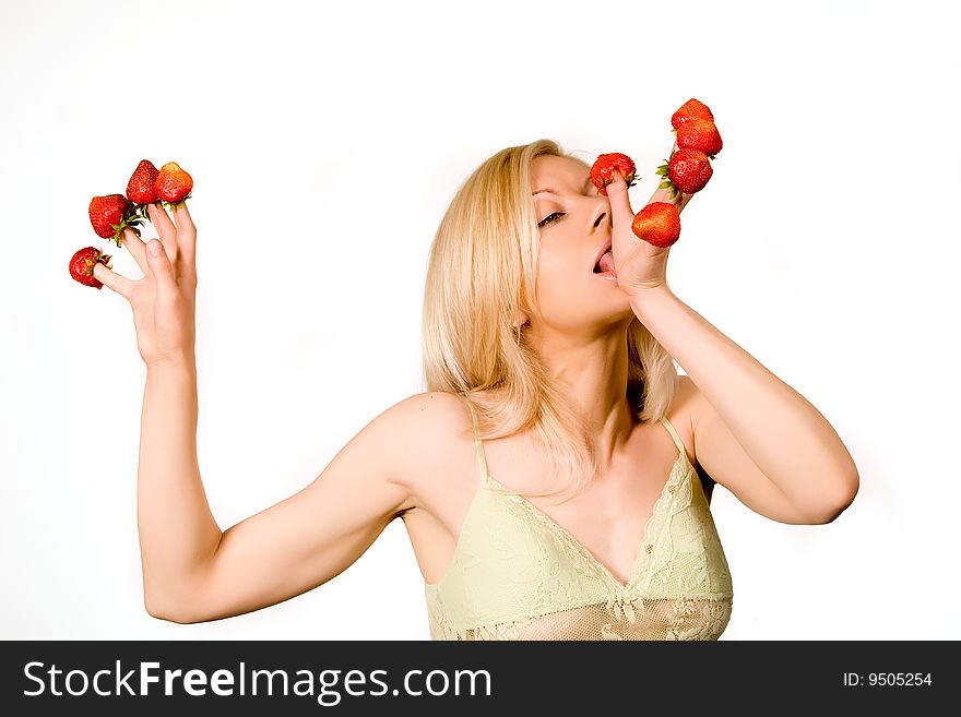 Sweet caucasian girl eating strawberries picked on fingertips