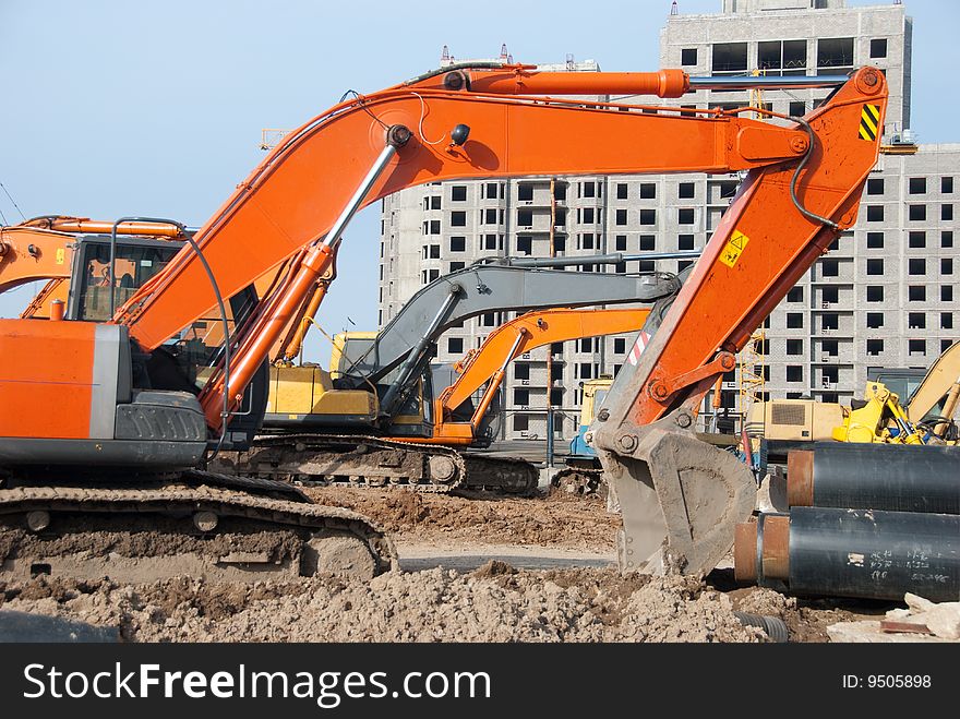 Excavators stand in a construction site