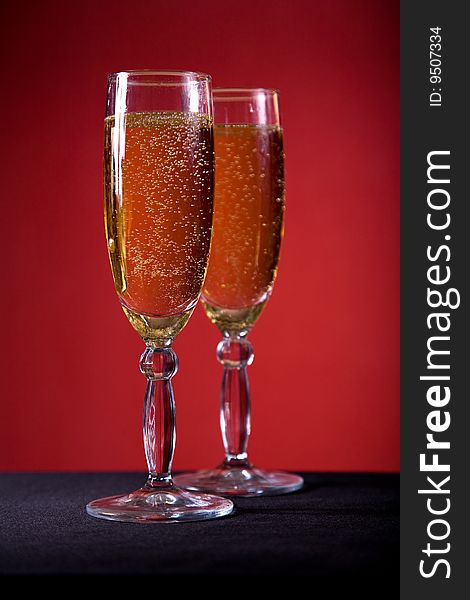 Champagne glasses over red background, selective focus