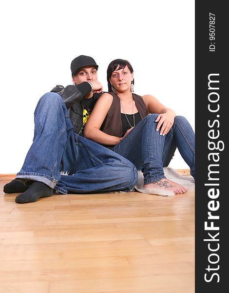 Young stylish couple sitting on the floor of their new home! Pure white wall leaves big copyspace. Young stylish couple sitting on the floor of their new home! Pure white wall leaves big copyspace.