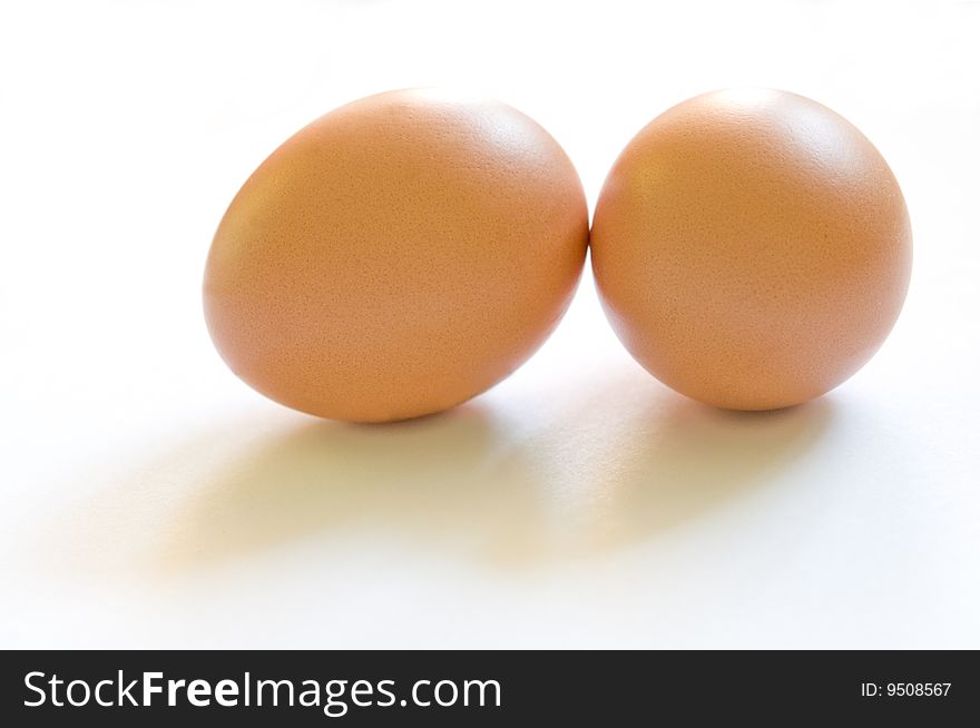 Two brown eggs with soft shadows in front