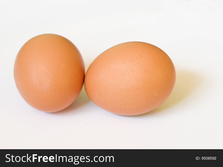 Two brown eggs with soft shadows