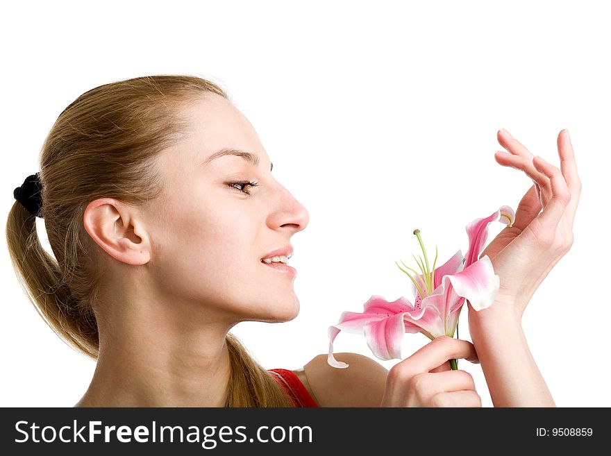 A portrait of a nice blond girl in red with a pink lily near her face on a white background. A portrait of a nice blond girl in red with a pink lily near her face on a white background