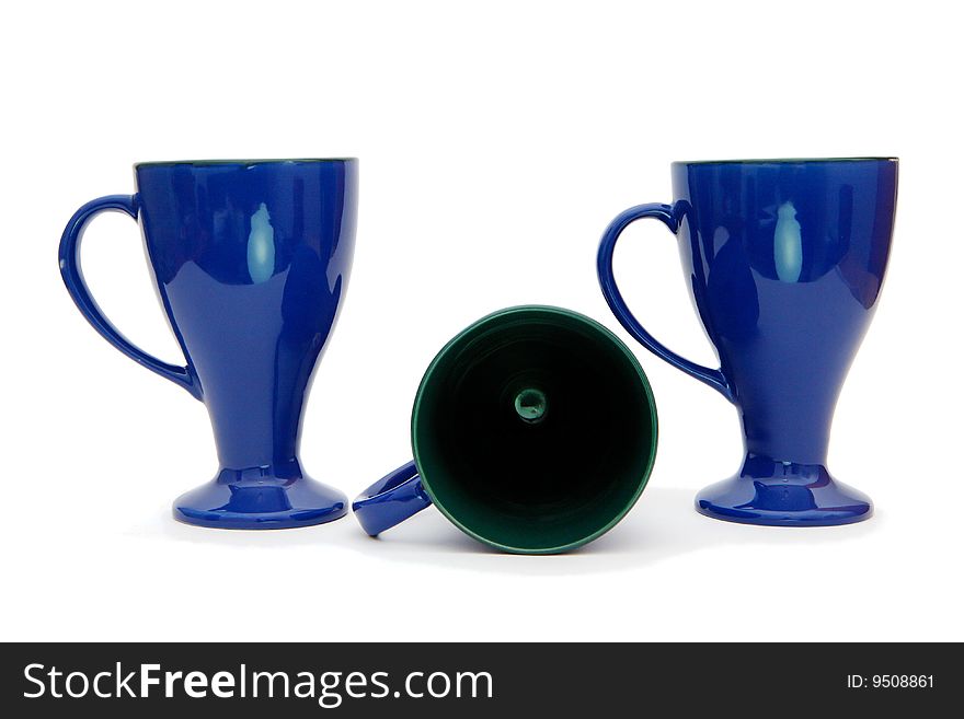 Two standing and one lying blue long-stemmed coffee cups isolated. Two standing and one lying blue long-stemmed coffee cups isolated