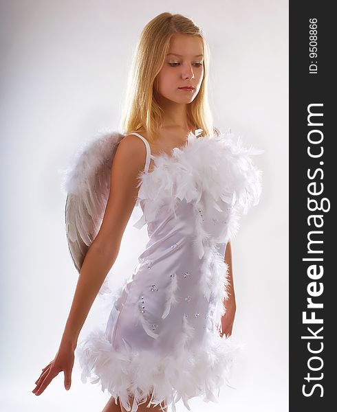 Young beautiful girl in a white dress with wings behind the back. Young beautiful girl in a white dress with wings behind the back