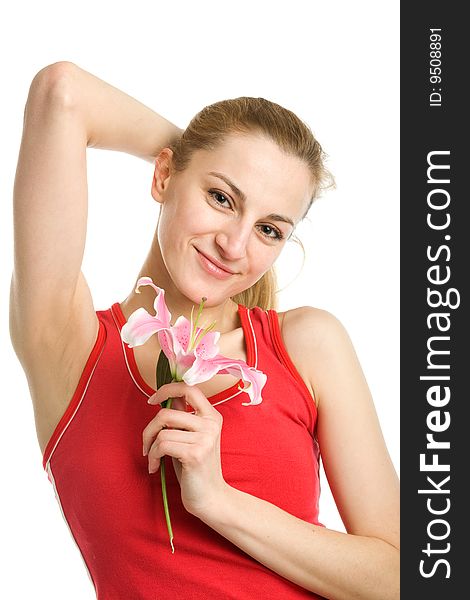 A smiling nice blond girl in red posing with a pink lily near her face on a white background. A smiling nice blond girl in red posing with a pink lily near her face on a white background