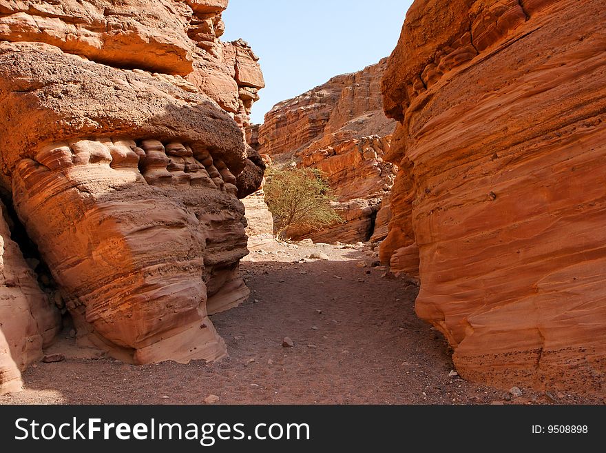 Narrow slot between two striped orange rocks in stone desert, Israel. Narrow slot between two striped orange rocks in stone desert, Israel