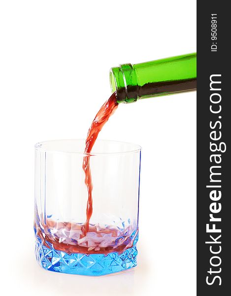 Red wine pouring down from a wine bottle into blue glass. Red wine pouring down from a wine bottle into blue glass