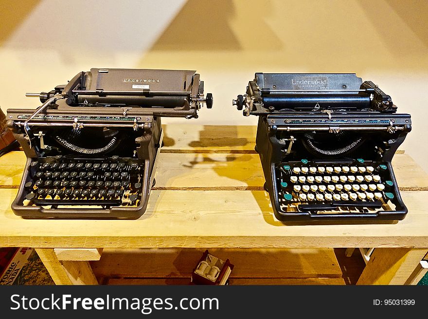 A pair of vintage typewriters on table.