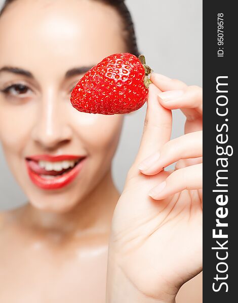 People, emotions, natural, food, beauty and lifestyle concept - Woman Eating Strawberry. Sensual Lips. Manicure and Lipstick. Desire. Beauty Girl Lips with Strawberry. white teeth