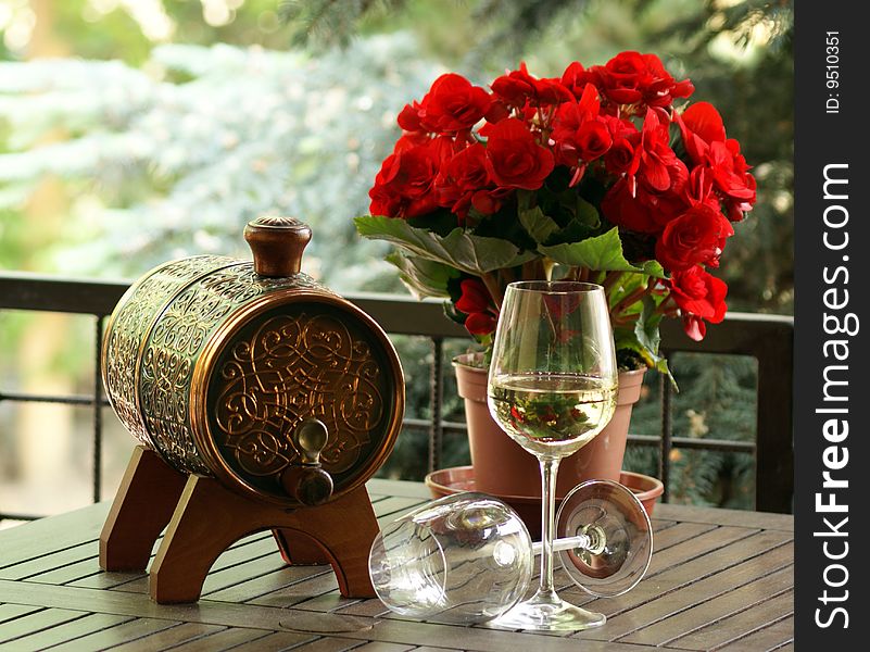 Wine with begonia in a wood table