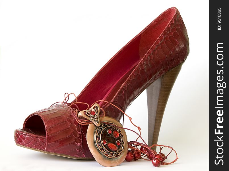 Red shoe with high heel and necklace