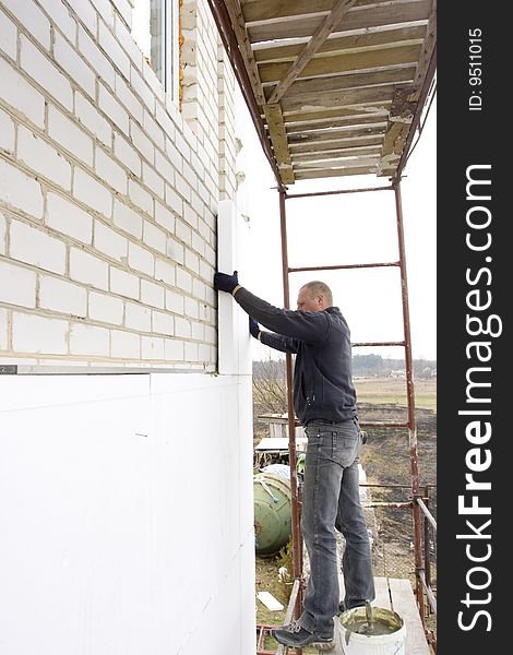 Master glue polystyrene the plate on wall of the building