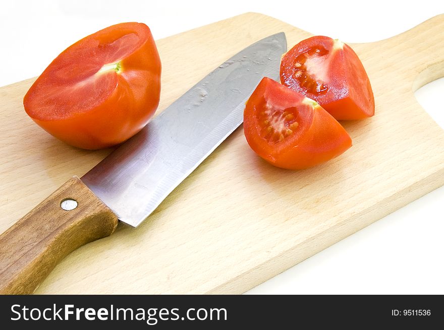 Chopped tomato and knife on beech wood choppping board