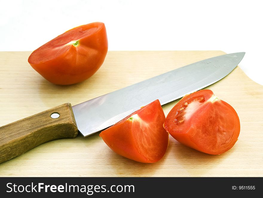 Chopped tomato and knife on beech wood choppping board. Chopped tomato and knife on beech wood choppping board