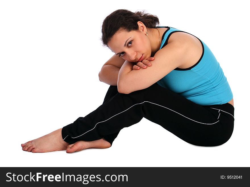 Brunet sport girl sits on floor posing. Isolated