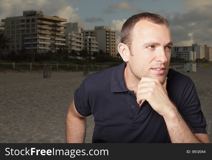 Young adult on the beach with his hand on his chin. Young adult on the beach with his hand on his chin