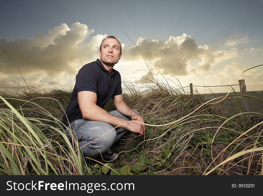 Attractive young man in the beach dunes during sunrise. Attractive young man in the beach dunes during sunrise