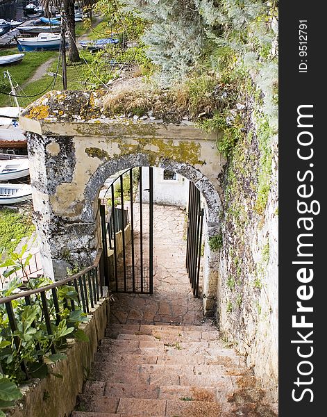 Entrance in old port, arch and gate with lichen and moss, Corfu, Greece