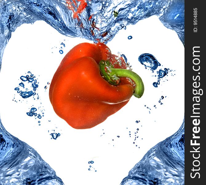 Red pepper with shape of heart from blue water