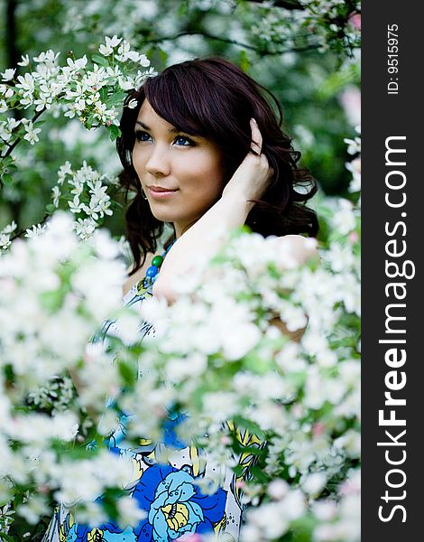 Tender girl in the garden with flowerings trees