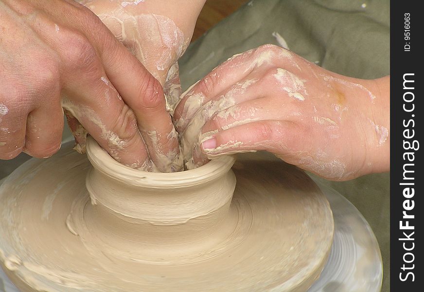Potter working with clay bowl on potter's wheel