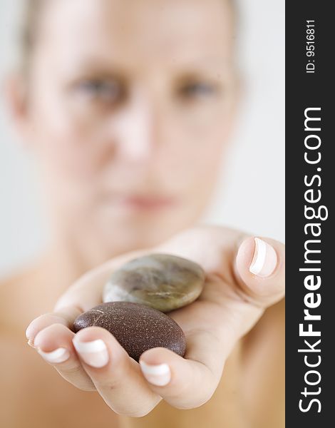 Young female holding out a couple of stones, only the front stone is in full focus. Young female holding out a couple of stones, only the front stone is in full focus