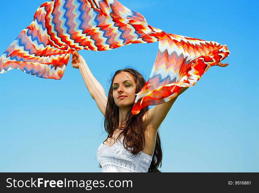 girl holding colorful scarf over blue sky. girl holding colorful scarf over blue sky