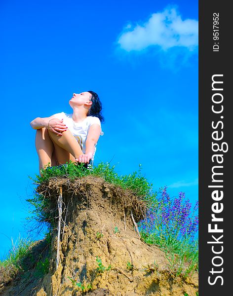 Girl sitting on a top of a hill. Girl sitting on a top of a hill