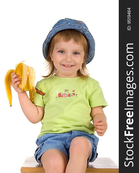 Little girl eats a banana. Studio shot