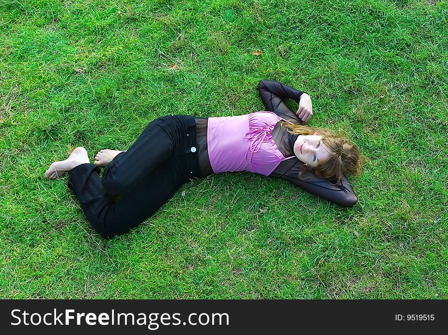 Young woman with red hairs lays in the grass. Young woman with red hairs lays in the grass