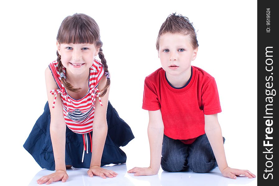 Cute blue-eyed boy and girl posing in the studio
