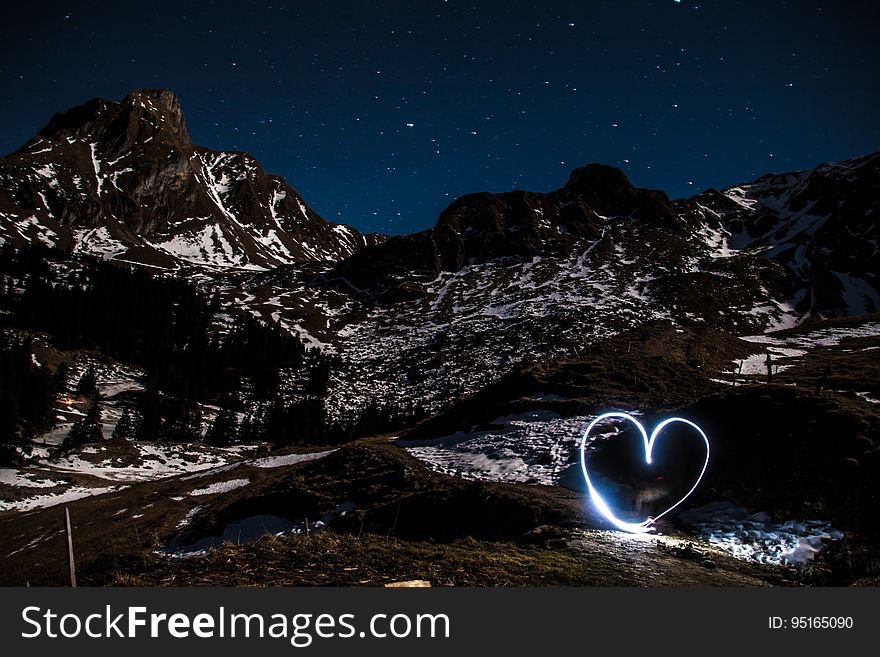 A long exposure with a heart light painting at mountains. A long exposure with a heart light painting at mountains.