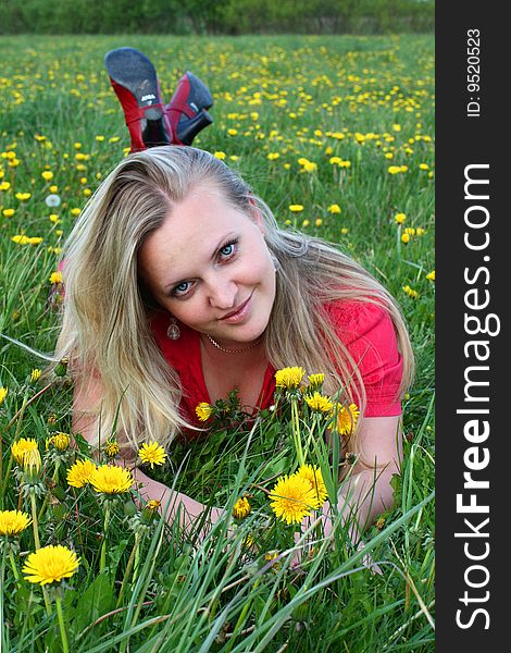 Young girl lying in dandelion meadow