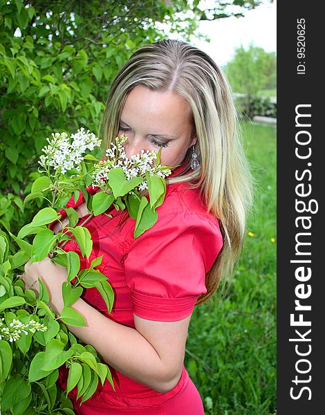 Young girl and blossoming lilac