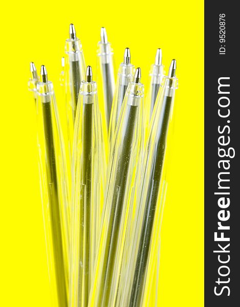 Ball point pens isolated against a yellow background