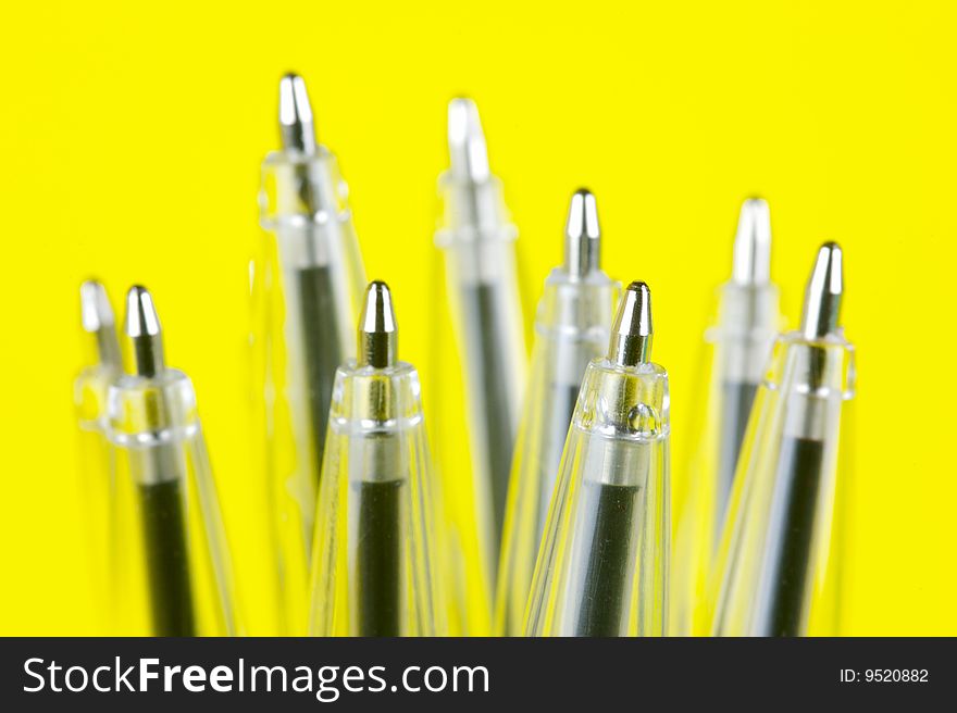 Ball point pens isolated against a yellow background