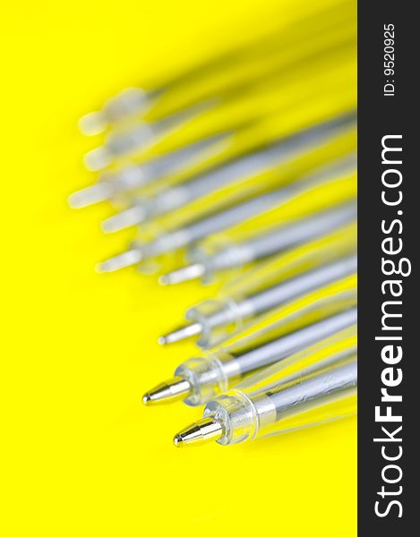 Ball point pens isolated against a yellow background