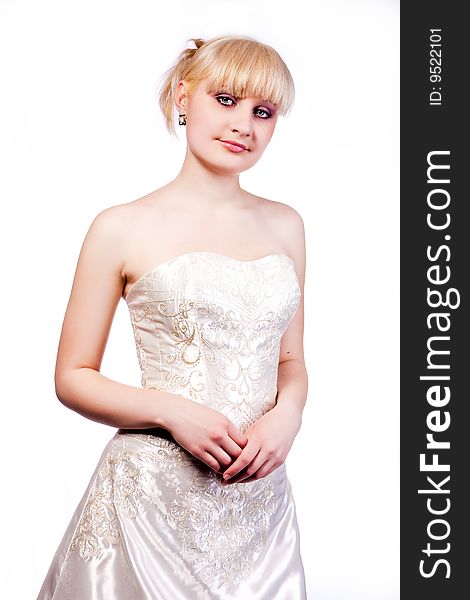 Blonde in wedding dress standing with hands crossed in front. Blonde in wedding dress standing with hands crossed in front