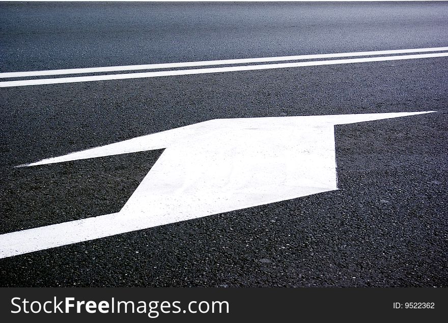 White sign on the road to turn left