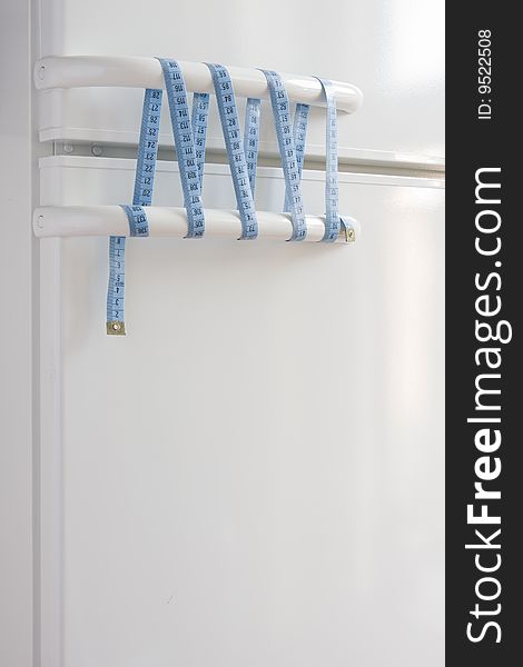 Concept image of keep diet, white fridge doors are tied (knotted) with bow measure tape