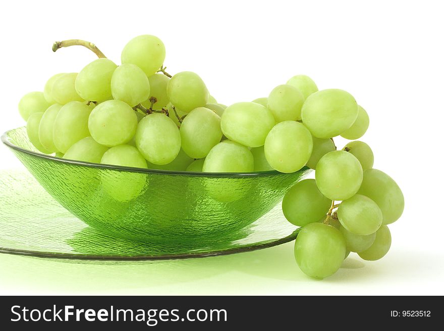 Green grape in the glass plates on a white background. Green grape in the glass plates on a white background