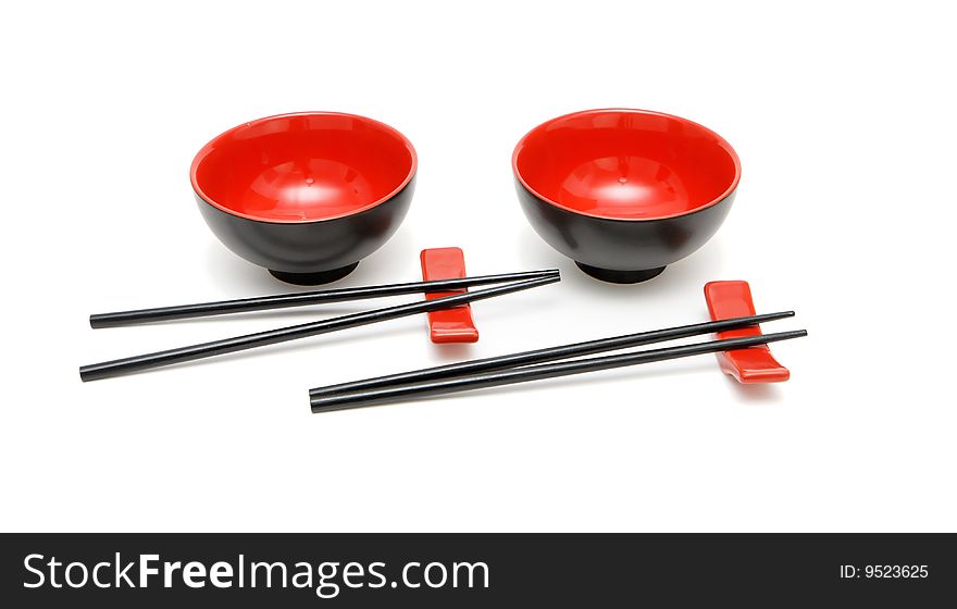 Two sets of chopsticks on stands alongside the red and black Japanese bowls. Two sets of chopsticks on stands alongside the red and black Japanese bowls