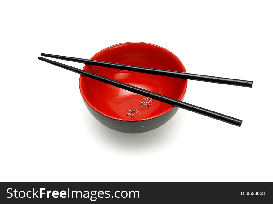 Chopsticks on  red and black bowl with kanji inscription isolated