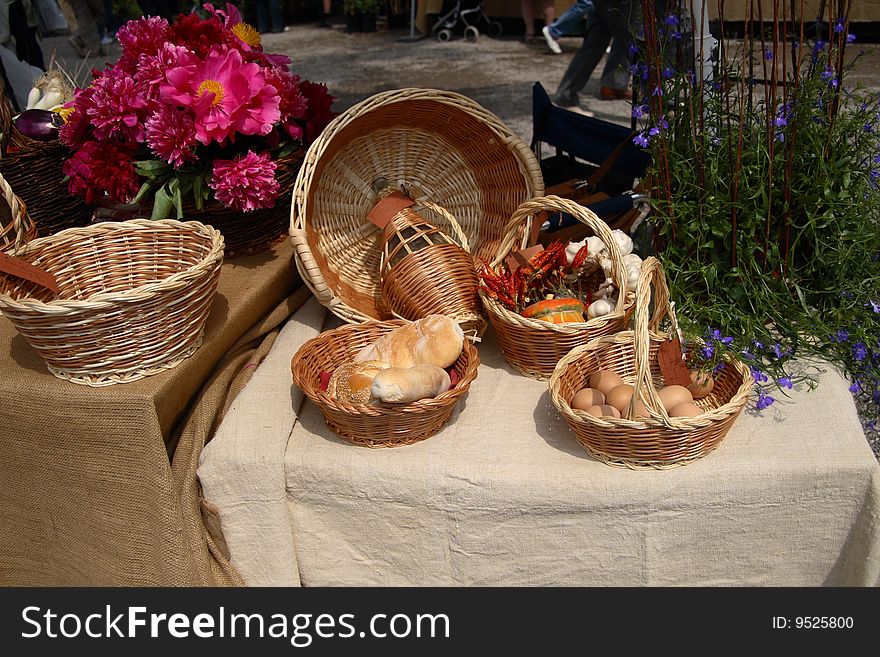 On the table in wicker baskets exposed eggs peppers garlic bread and a flask of wine. On the table in wicker baskets exposed eggs peppers garlic bread and a flask of wine