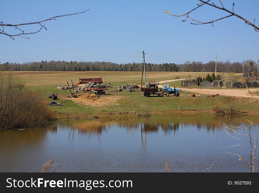 Landscape with old tractors against lake